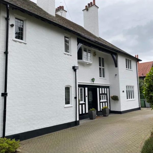 House with painted white walls and black wooden guttering